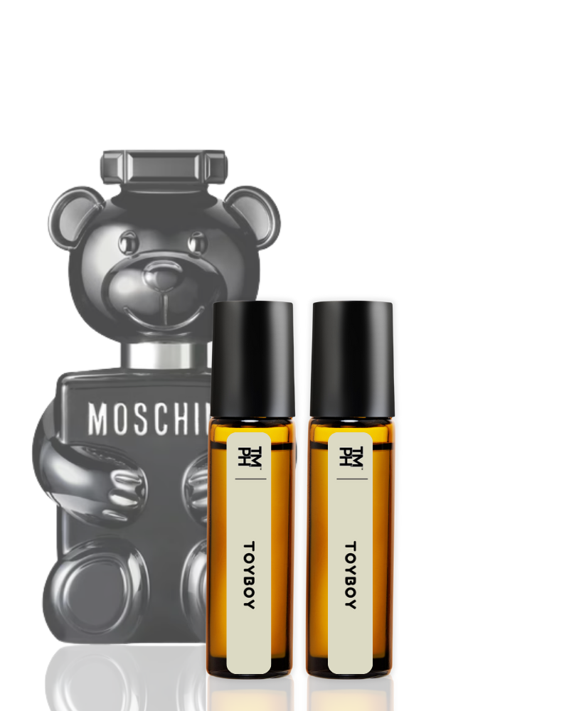 Two small bottles of perfume with black caps and white labels, placed in front of a Moschino bear-shaped product.