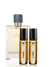 Perfume set with a large bottle and two smaller rollerball bottles on a white background